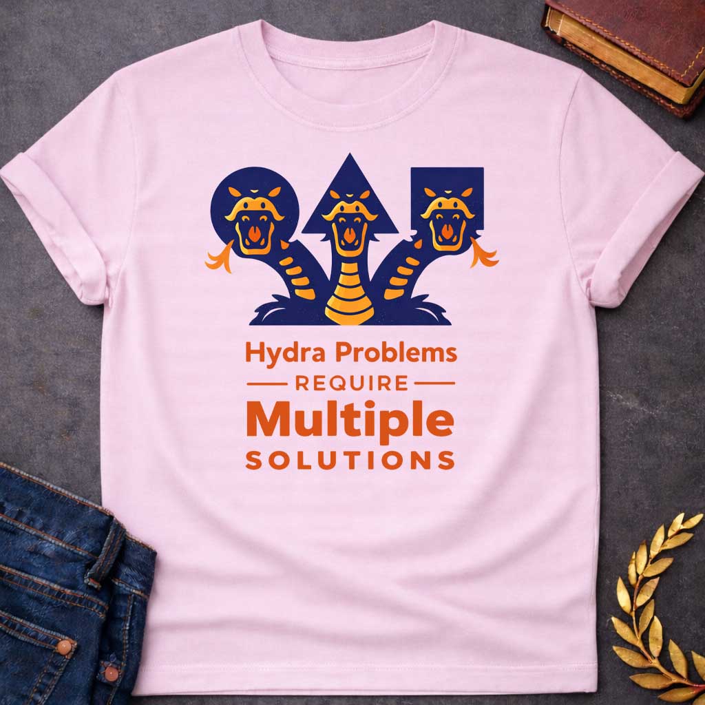 Light Pink T-shirt with a graphic featuring a bold modern illustrated design of the Hydra, the multi-headed serpent of Greek mythology, depicted as three snarling orange and navy snake heads rising against geometric navy shapes a circle, triangle, and rectangle.  Bold orange text below reads "Hydra Problems Require Multiple Solutions" with "Require" flanked by horizontal rules in a smaller weight