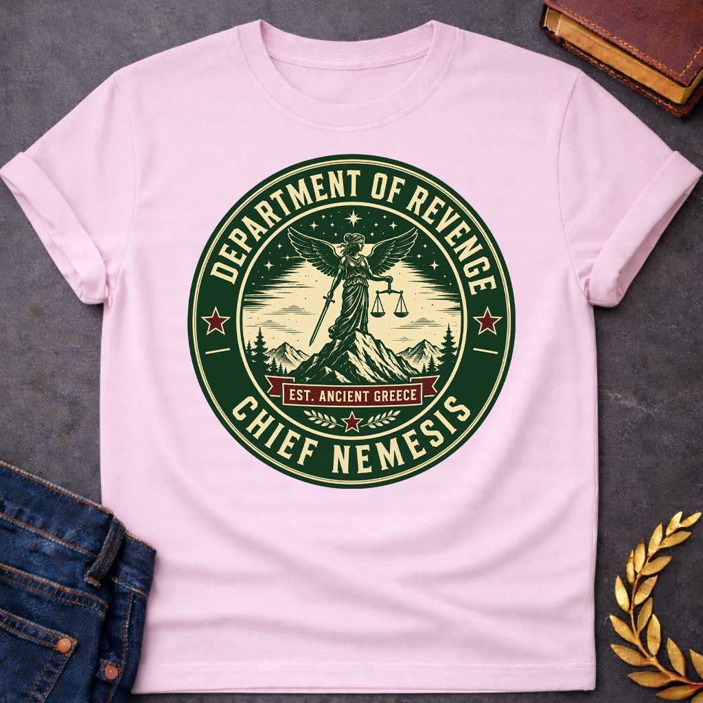 Light Pink T-Shirt with an Official seal-style circular design in forest green, cream, and burgundy red. Features Nemesis, the winged Greek goddess, standing on a mountain peak holding scales of justice and a sword. Starry night sky, pine trees, and snow-capped mountains surround her. Text reads 'DEPARTMENT OF REVENGE' at top, 'CHIEF NEMESIS' at bottom, with 'EST. ANCIENT GREECE' on a burgundy banner. Red stars accent the design. Humorous parody of official government seals celebrating divine justice.