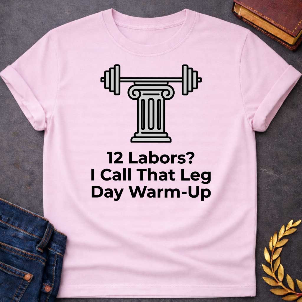 Light Pink T-shirt with a graphic design. At the top, there is a gray illustration of a classical Greek column supporting a barbell with weight plates on both sides. Below the illustration, the black text reads: "12 Labors? I Call That Leg Day Warm-Up"