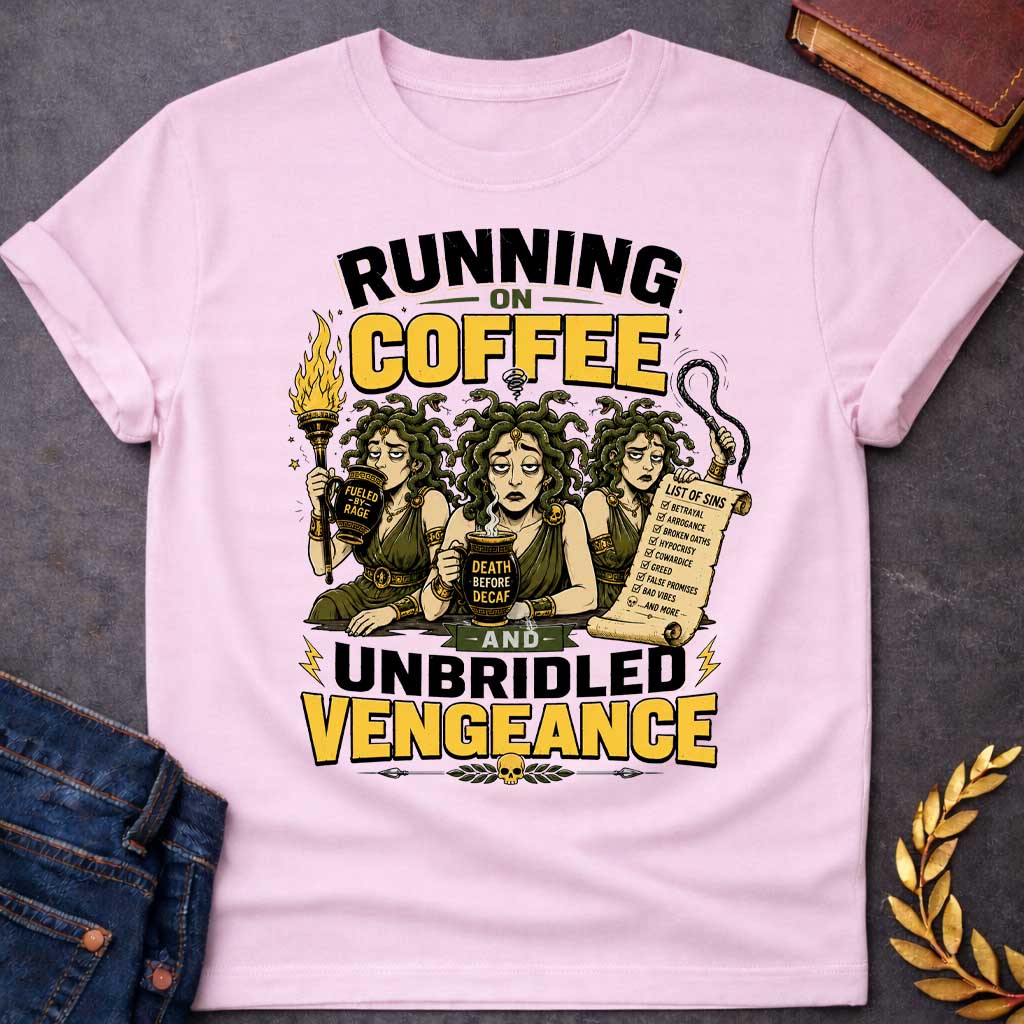 Light Pink T-shirt with a Humorous illustration blending Greek mythology with coffee culture. Three Furies with serpent hair wear classical robes holding symbols of vengeance. Left holds a flaming torch labeled 'Fueled by Rage,' center holds a coffee cup reading 'Death Before Decaf,' right carries a scroll listing sins. Text reads 'Running on Coffee and Unbridled Vengeance' above and below. Gold and black scheme celebrates divine justice powered by caffeine addiction.