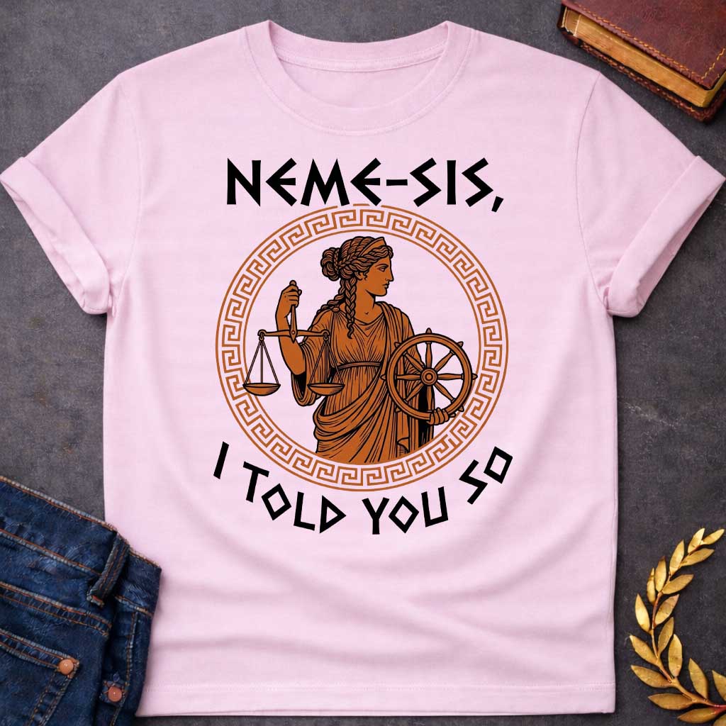 Light Pink T-shirt with an Ancient Greek pottery-style illustration of Nemesis, the goddess of divine retribution, rendered in terracotta and black. She wears flowing robes and holds balanced scales of justice in one hand and a ship's wheel in the other, symbolizing fate and accountability. Her braided hair is styled in classical Greek fashion. Enclosed in a Greek key pattern circular border. Bold text reads 'NEMESIS, I TOLD YOU SO' above and below. References the goddess who ensures justice.