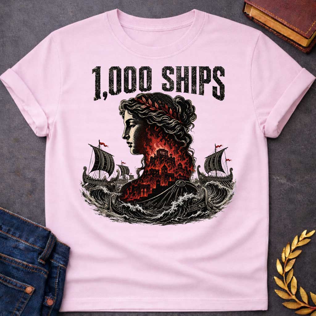 Light Pink T-shirt with a dramatic illustration of Helen of Troy in profile with curly hair and red laurel crown. Her silhouette contains the burning city of Troy in red and black flames. Greek warships with red flags sail through turbulent waves on either side. Bold distressed text reads '1,000 SHIPS' above. References the famous phrase 'the face that launched a thousand ships' describing Helen's beauty that sparked the Trojan War.