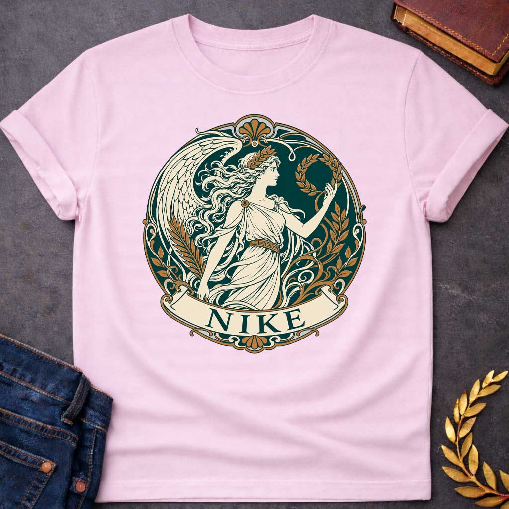 Light Pink T-shirt with a Classical medallion design in teal, cream, and gold depicting Nike, the Greek goddess of victory. She wears a flowing chiton and holds a laurel wreath, shown in profile with long wavy hair crowned by another laurel wreath. Large detailed wings extend behind. Ornate Art Nouveau border features scrollwork, gold floral elements, and Greek key patterns. Banner below reads 'NIKE' in teal. Celebrates victory, achievement, and athletic glory in classical style.