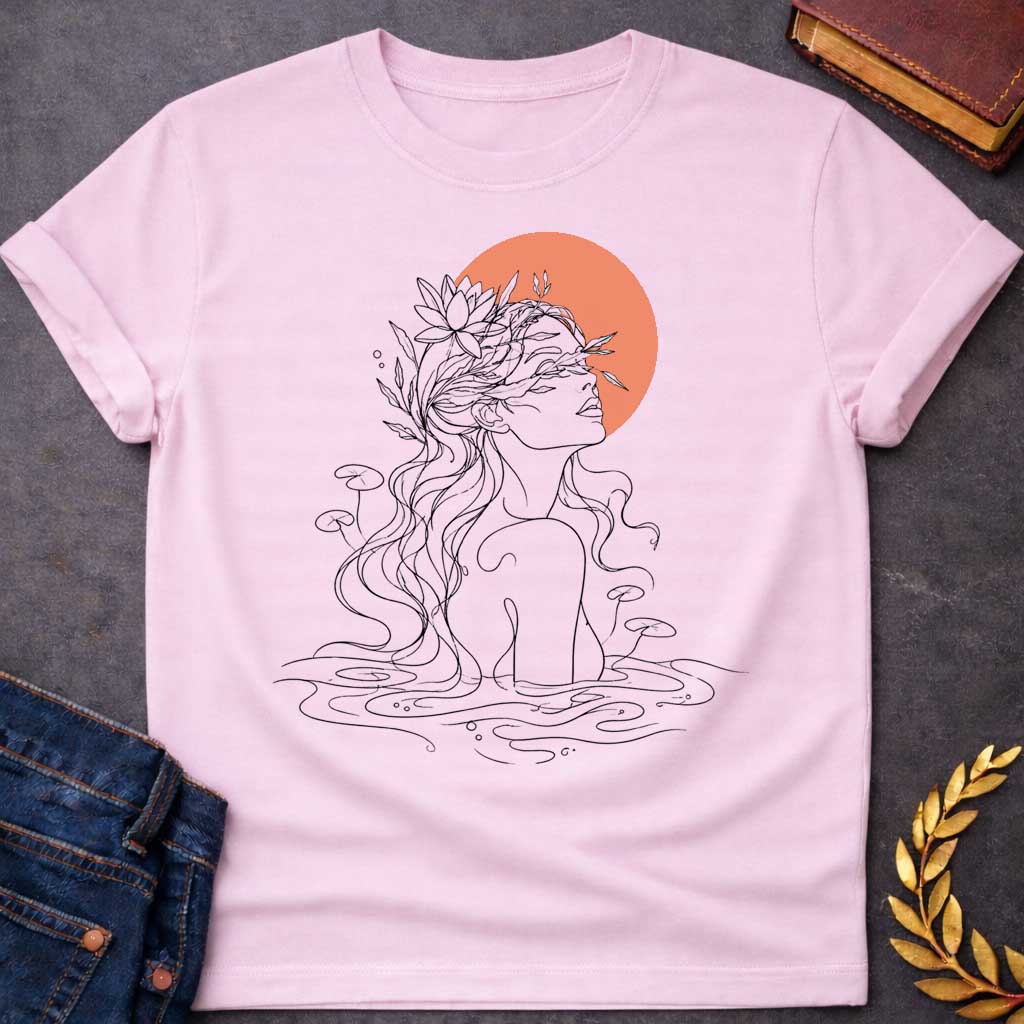 Light Pink T-shirt with a minimalist, single-line art illustration of a water nymph. The design features the profile of a woman emerging from a stylized pond, with flowing hair adorned with water lilies and aquatic plants. The sun is represented by a solid, warm terracotta circle behind her head. The graphic uses fine black lines on a clean background, creating a serene, modern, and nature-inspired aesthetic