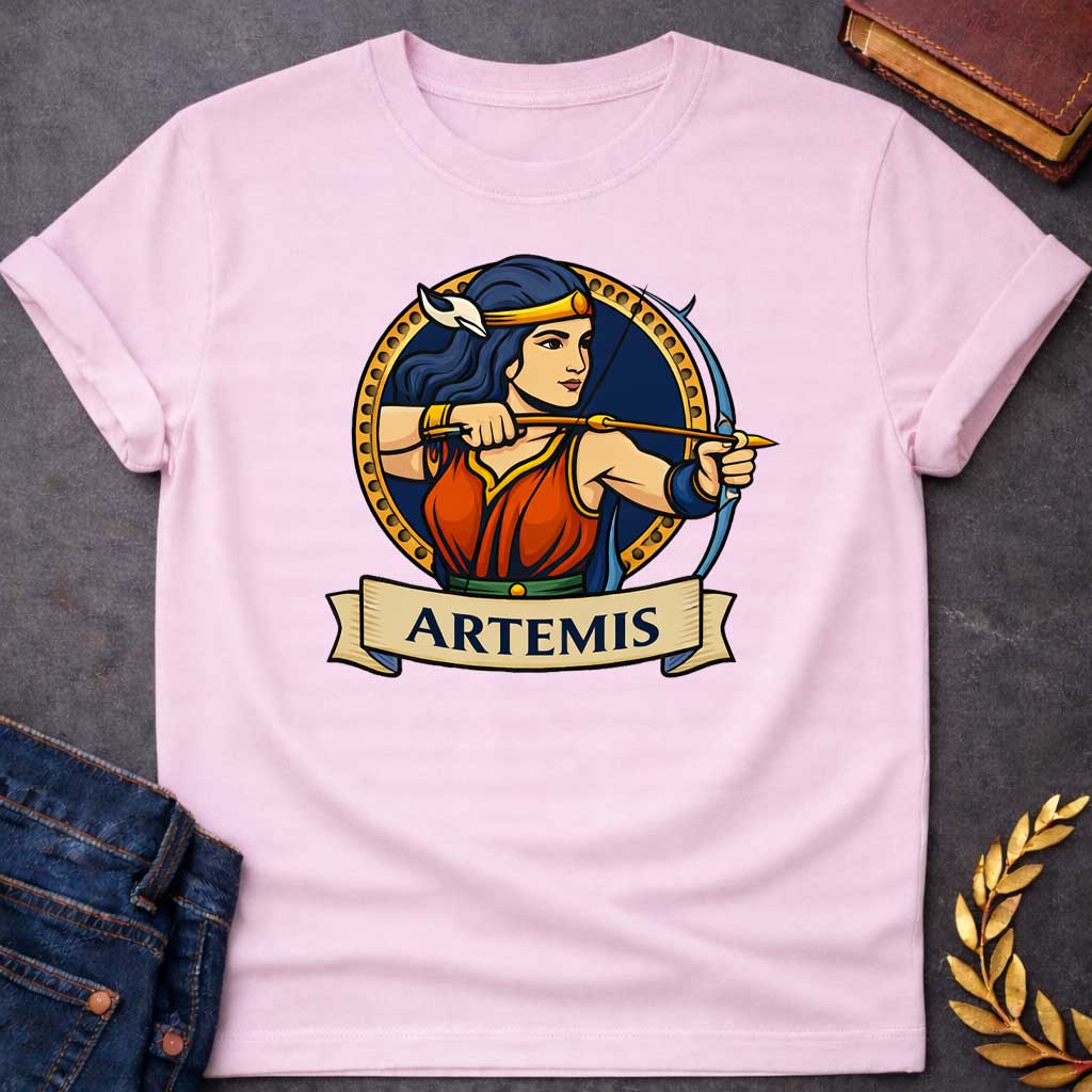Light Pink T-shirt graphic featuring a vibrant illustrated portrait of Artemis, the Greek Goddess of the Hunt, with long dark blue hair and a gold headband adorned with a white crescent moon, wearing a red and blue draped gown with a green belt, drawn back in a dynamic archery pose with a bow and arrow aimed forward. She is framed within a gold circular border against a navy background, with a scroll banner below reading "Artemis," in a bold tattoo-inspired style with navy, gold, and red tones