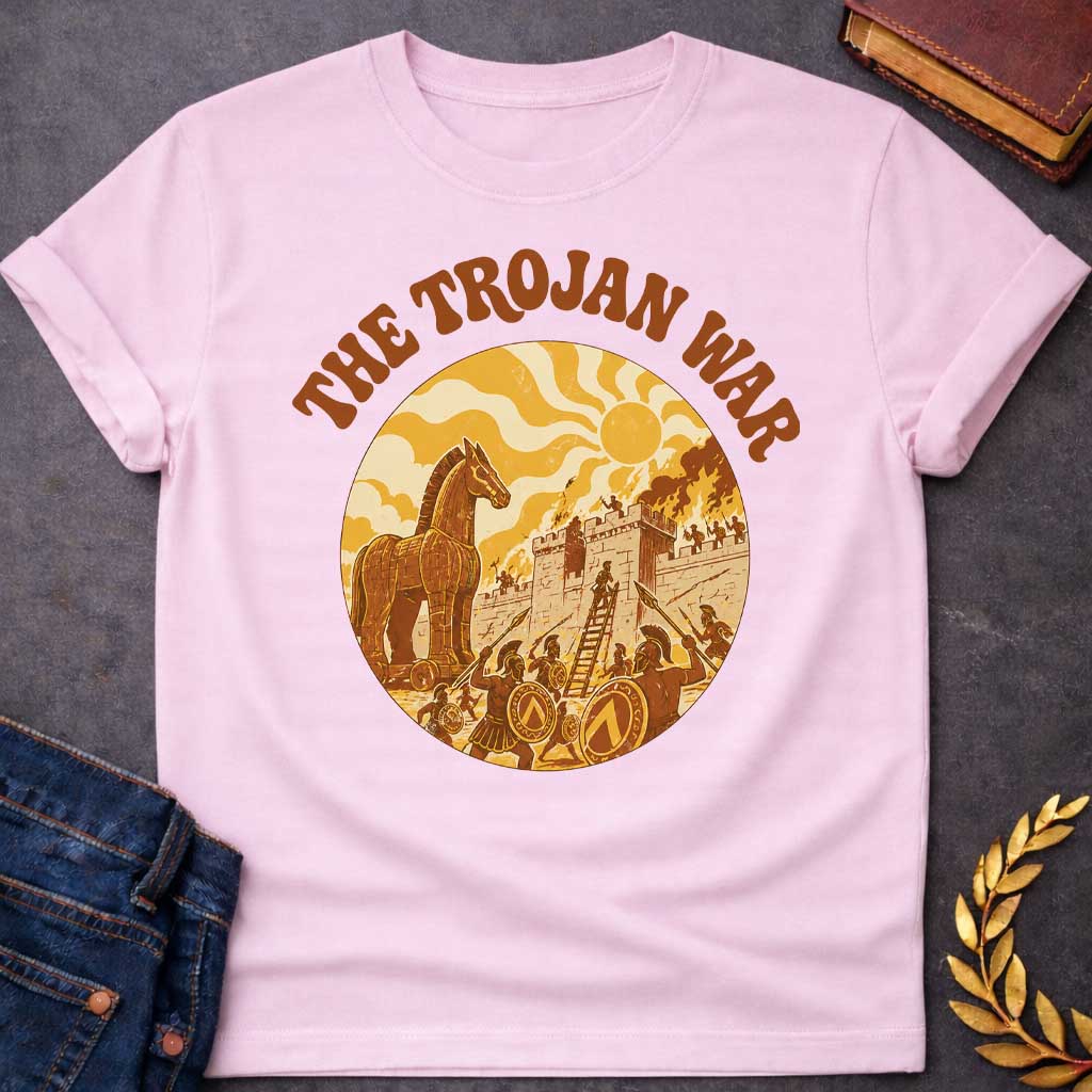 Light Pink T-shirt featuring bold groovy 1970s-style arched brown text reading "The Trojan War" above a circular vintage illustration depicting the siege of Troy — the Trojan Horse stands to the left while Greek warriors with Spartan shields and spears storm the burning walls of Troy using a ladder, under a stylized wavy sun, rendered in a warm retro palette of golden yellow, burnt orange, and brown tones