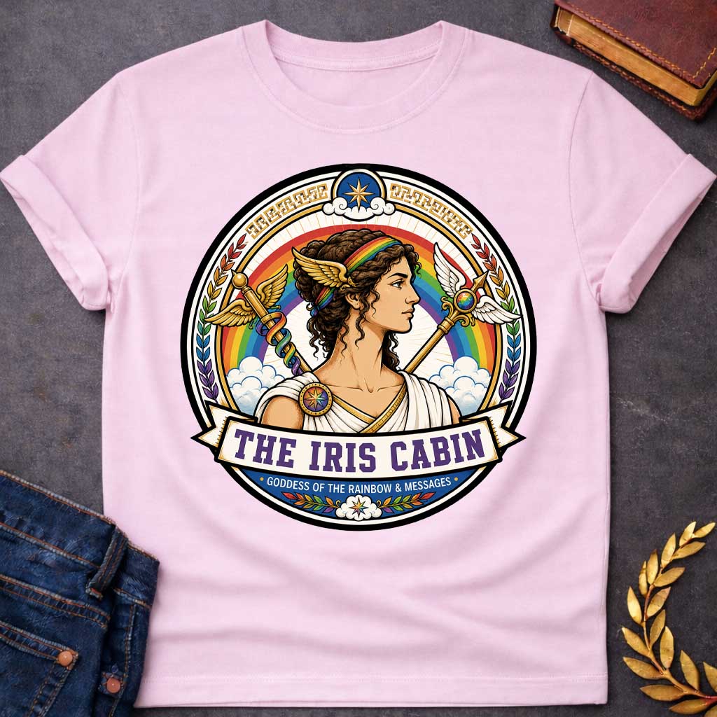 Light Pink t-shirt with a Iris Greek mythology cabin design featuring the goddess of the rainbow and messages in a colorful circular emblem. Iris wears a rainbow headband and winged accents, surrounded by a vibrant rainbow, clouds, winged staffs, laurel leaves, and celestial details. Text reads “The Iris Cabin” and “Goddess of the Rainbow & Messages,”