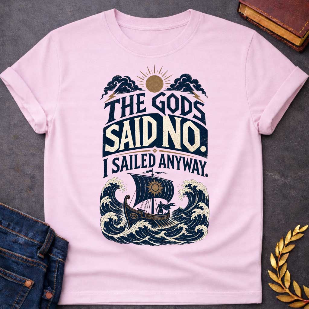 Light Pink t-shirt with a Vintage Greek mythology design featuring the bold phrase “The Gods Said No. I Sailed Anyway.” An ancient Greek ship battles towering ocean waves beneath storm clouds, lightning bolts, and a glowing sun. Distressed navy, cream, and gold artwork captures the defiant spirit of Odysseus and The Odyssey.
