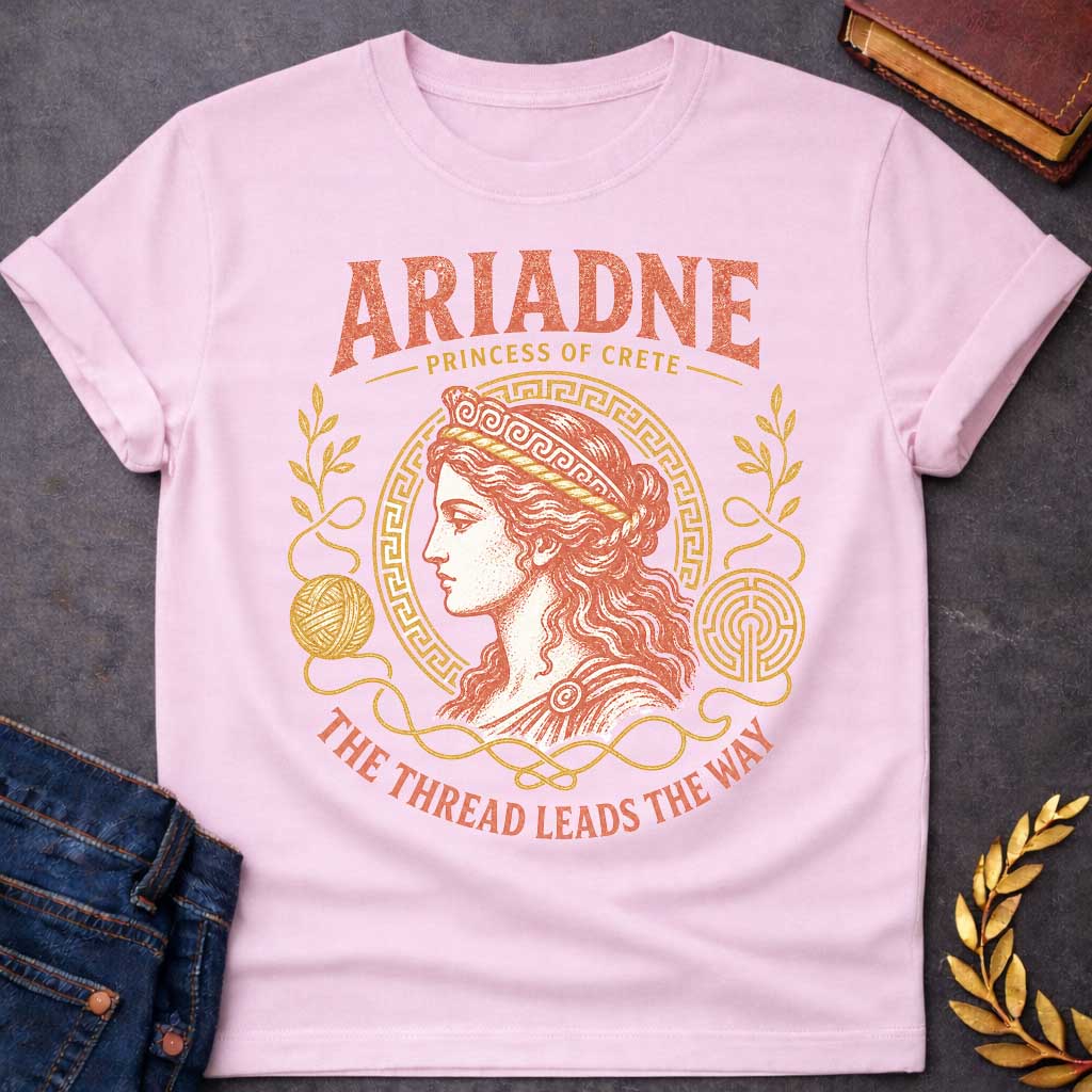 Light Pink t-shirt with a Vintage Greek mythology design featuring Ariadne, Princess of Crete, in a classical portrait framed by a Greek key border, golden thread, yarn, laurel branches, and a labyrinth. Warm coral and gold engraving-style artwork is paired with the phrase "The Thread Leads the Way," inspired by Ariadne's role in helping Theseus escape the Minotaur's labyrinth.
