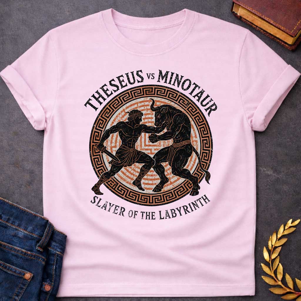 Light PInk T-shirt with A vintage, Greek pottery-style graphic depicting a battle. At the center, the muscular hero Theseus holds a sword as he wrestles the powerful Minotaur. The black figure silhouettes are set against an orange labyrinth pattern inside a circular frame with a Greek key border. Distressed text reads "THESEUS VS MINOTAUR" arched across the top and "SLAYER OF THE LABYRINTH" curved along the bottom.