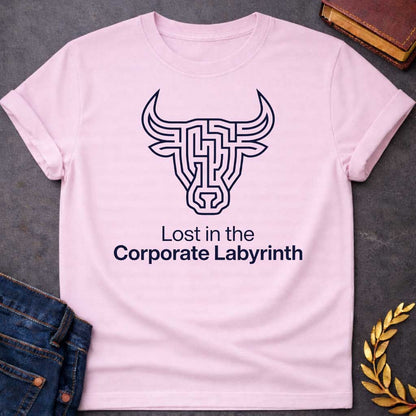 Light Pink T-shirt with a Minimalist line art illustration of a Minotaur head rendered entirely as a complex maze pattern in navy blue and white. The bull's horns and facial features form pathways and corridors. Text reads 'Lost in the Corporate Labyrinth' below. Clever wordplay merges Greek mythology with modern commentary on workplace frustration, bureaucratic confusion, and corporate system entrapment.