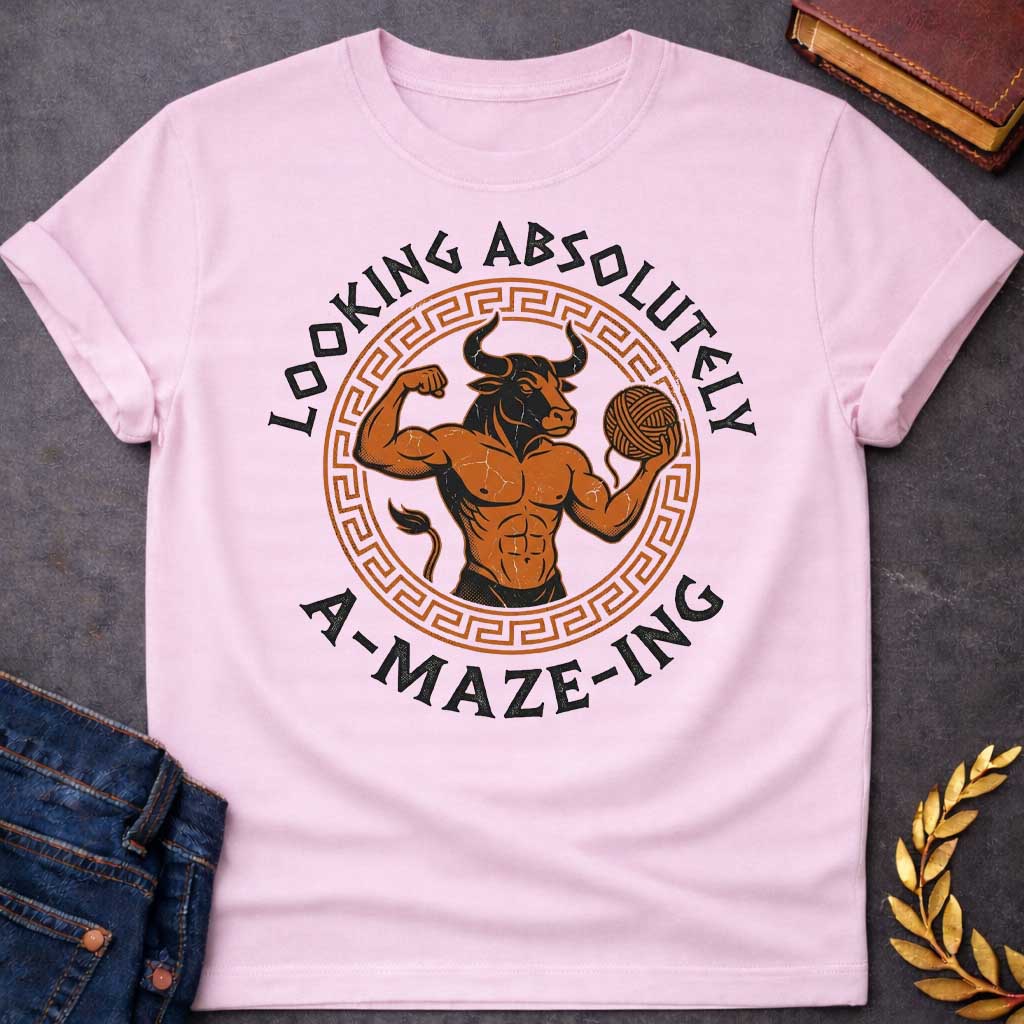 Light Pink T-shirt with a Fitness-themed design of a muscular Minotaur displaying impressive abdominal definition and flexing one arm. The bull-headed figure holds a ball of yarn in the other hand, referencing the mythological thread used to escape the labyrinth. Terracotta orange and brown coloring with defined musculature. Greek key pattern border frames the circular composition. Text reads 'Looking Absolutely A-Maze-Ing' in bold black lettering. Clever wordplay blends gym culture with Greek mythology.