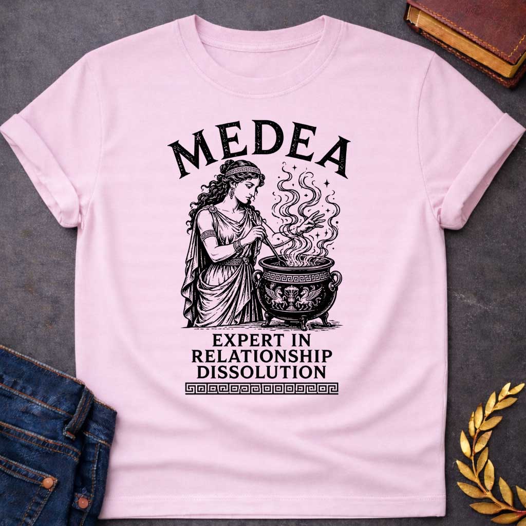 Light Pink T-shirt with a Classical engraving of Medea, the legendary Greek sorceress, in flowing draped robes with Greek key pattern headband. She stirs a decorative cauldron with magical swirling smoke and stars rising dramatically from within. Black and white line art style with intricate detailing. Text reads 'Medea' above and 'Expert in Relationship Dissolution' below with Greek key border. Dark humor celebrates Medea's infamous reputation for magical vengeance and relationship destruction.