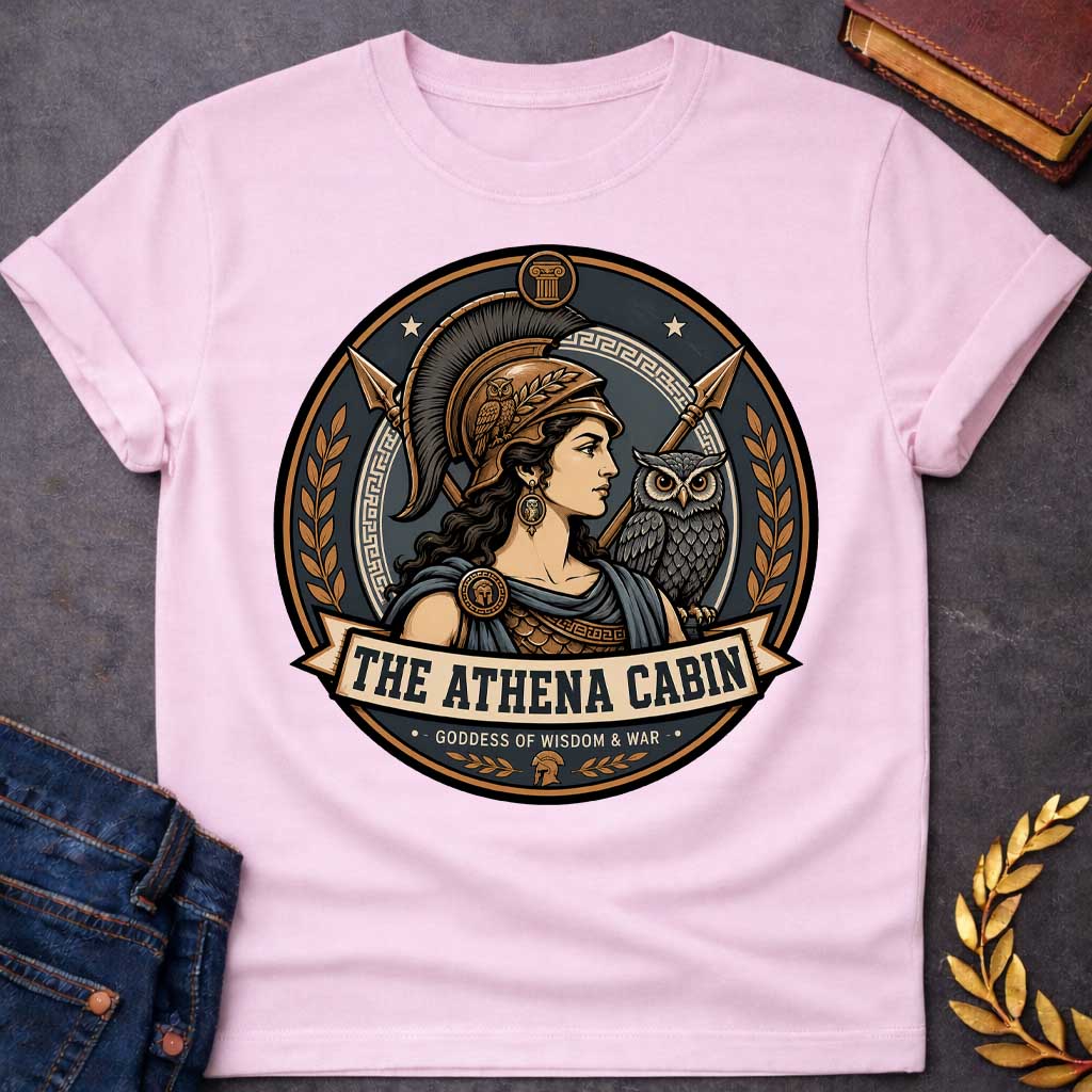 Light Pink t-shirt with a Athena Greek mythology cabin design featuring the goddess of wisdom and war in a bronze warrior helmet, accompanied by her sacred owl and crossed spears. Bronze, charcoal, and cream circular camp-style emblem features Greek key details, laurel branches, and the text “The Athena Cabin” and “Goddess of Wisdom & War.”