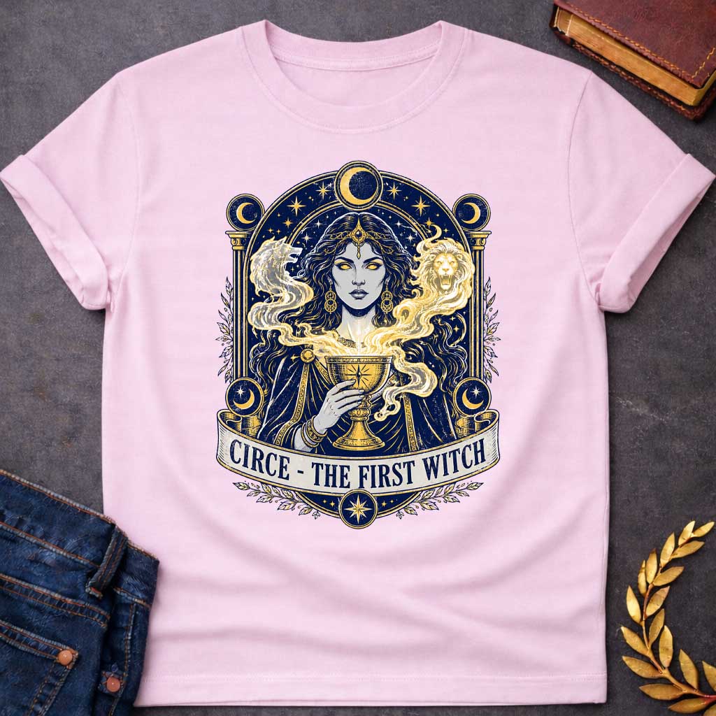 Light Pink T-shirt with a Mystical tarot-style portrait of Circe, the first witch from Greek mythology, rendered in navy blue and gold. She displays golden glowing eyes and magical hair infused with light energy. Twin lion heads flank her head symbolizing divine power. She holds an ornate golden goblet overflowing with luminous magic. Moon phases in crescent form circle her ethereal figure. Ornate architectural frame with columns and celestial decorations. Gold stars scatter throughout. Banner reads 'Circe 