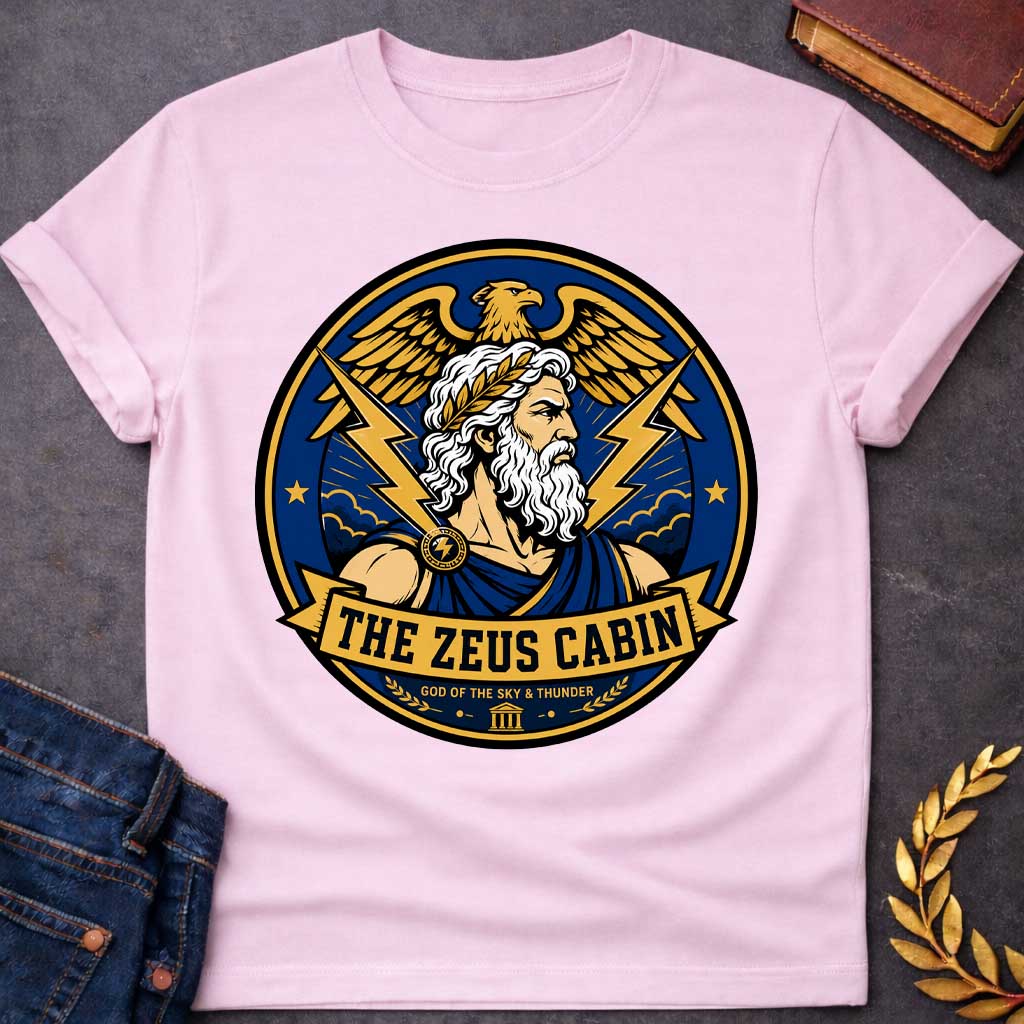Light Pink t-shirt with a Zeus Greek mythology cabin design featuring the bearded god of the sky and thunder with a laurel crown, golden eagle, lightning bolts, storm clouds, and Greek temple symbol. Bold blue, gold, white, and black circular camp-style emblem includes the text “The Zeus Cabin” and “God of the Sky & Thunder.”