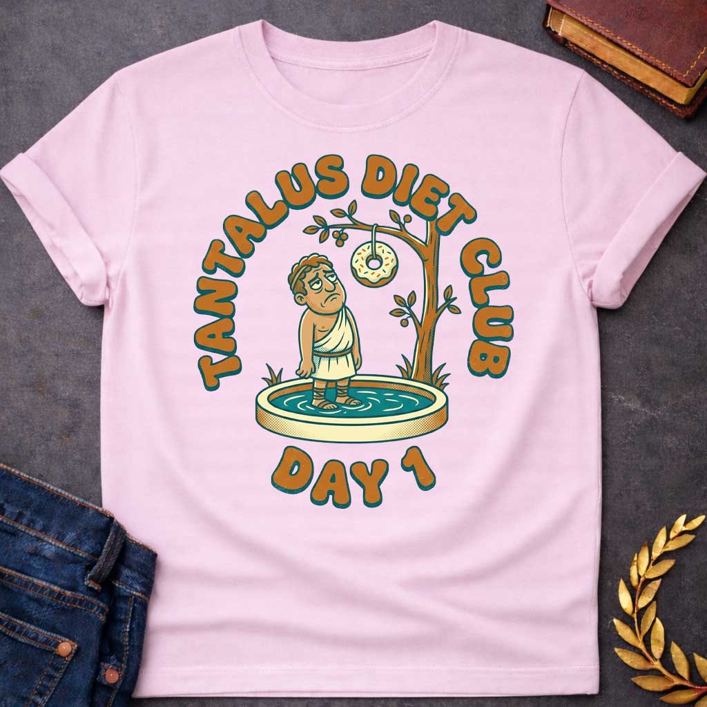 Light Pink t-shirt with A cartoon illustration, Standing in a small shallow pool next to a tree, a sad Greek man in a toga gazes glumly at a frosted donut with sprinkles dangling just out of reach from a branch. Chunky, retro orange and teal text arches over the graphic reading "TANTALUS DIET CLUB", with "DAY 1" featured prominently at the bottom.