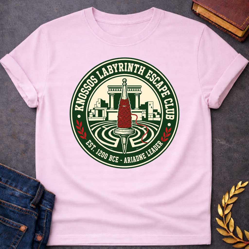 Light Pink T-shirt with A circular, collegiate-style emblem t-shirt design, The logo features a cream center showing a wooden spindle wrapped in bright red thread, positioned over a labyrinth with ancient Minoan ruins behind it. The dark green outer ring reads "KNOSSOS LABYRINTH ESCAPE CLUB" along the top and "EST. 1200 BCE - ARIADNE LEADER" at the bottom, separated by small red laurel branches.