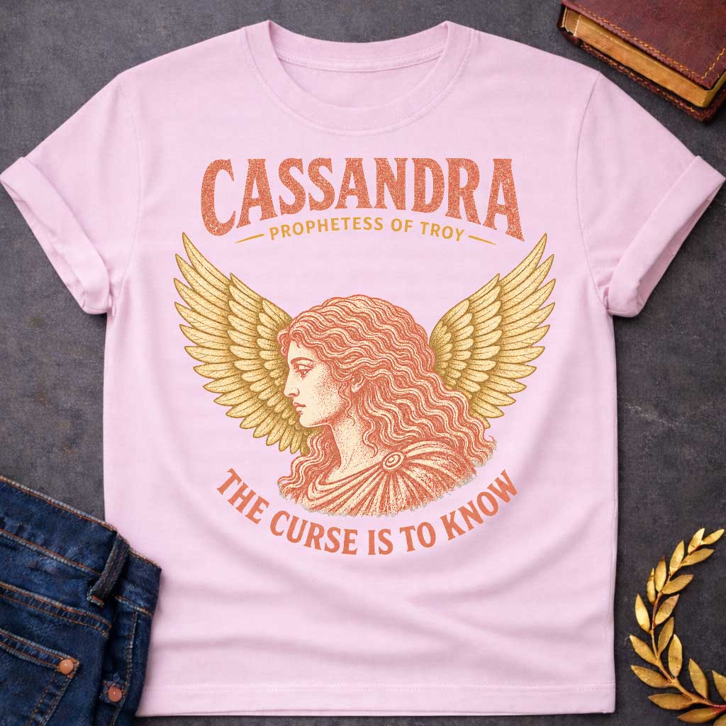 Light Pink t-shirt with a Vintage Greek mythology design featuring Cassandra, prophetess of Troy, in a classical portrait framed by dramatic golden wings. Warm coral and gold engraving-style artwork accompanies bold text reading "Cassandra – Prophetess of Troy" and "The Curse Is to Know," inspired by her tragic gift of prophecy and the curse that no one would believe her warnings.