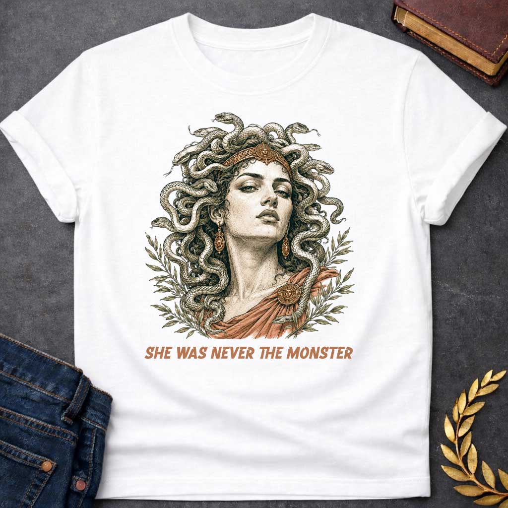 White t-shirt with A Detailed vintage engraving-style Greek mythology t-shirt design featuring Medusa with an intense expression, a crown, and numerous snakes twisting through her hair. Olive branches frame the portrait, with bronze and terracotta accents adding an ancient classical feel. Bold text below reads "She Was Never the Monster," creating a dramatic reinterpretation of the Medusa myth.