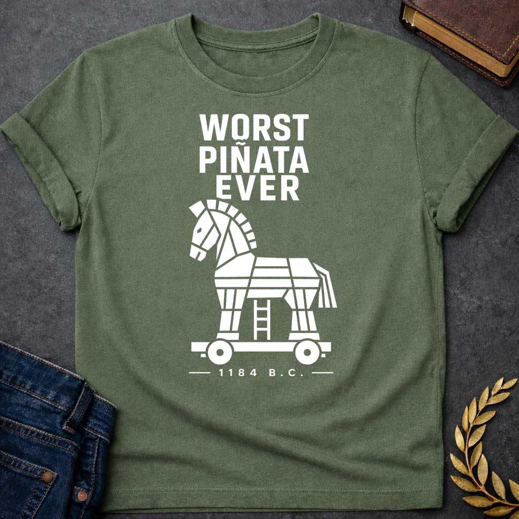 Military Green T-shirt with a graphic in white featuring bold condensed sans-serif text reading "Worst Piñata Ever" above a detailed flat geometric white silhouette illustration of the Trojan Horse on a wheeled platform with a visible ladder underneath, with a small datestamp below reading "— 1184 B.C. —" — a humorous reference to the Greek legend of the Trojan War