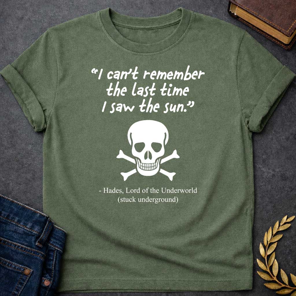 Military Green T-shirt graphic in black and white featuring a handwritten-style quote reading "I can't remember the last time I saw the sun." above a classic skull and crossbones illustration, with the humorous attribution below reading "- Hades, Lord of the Underworld (stuck underground)