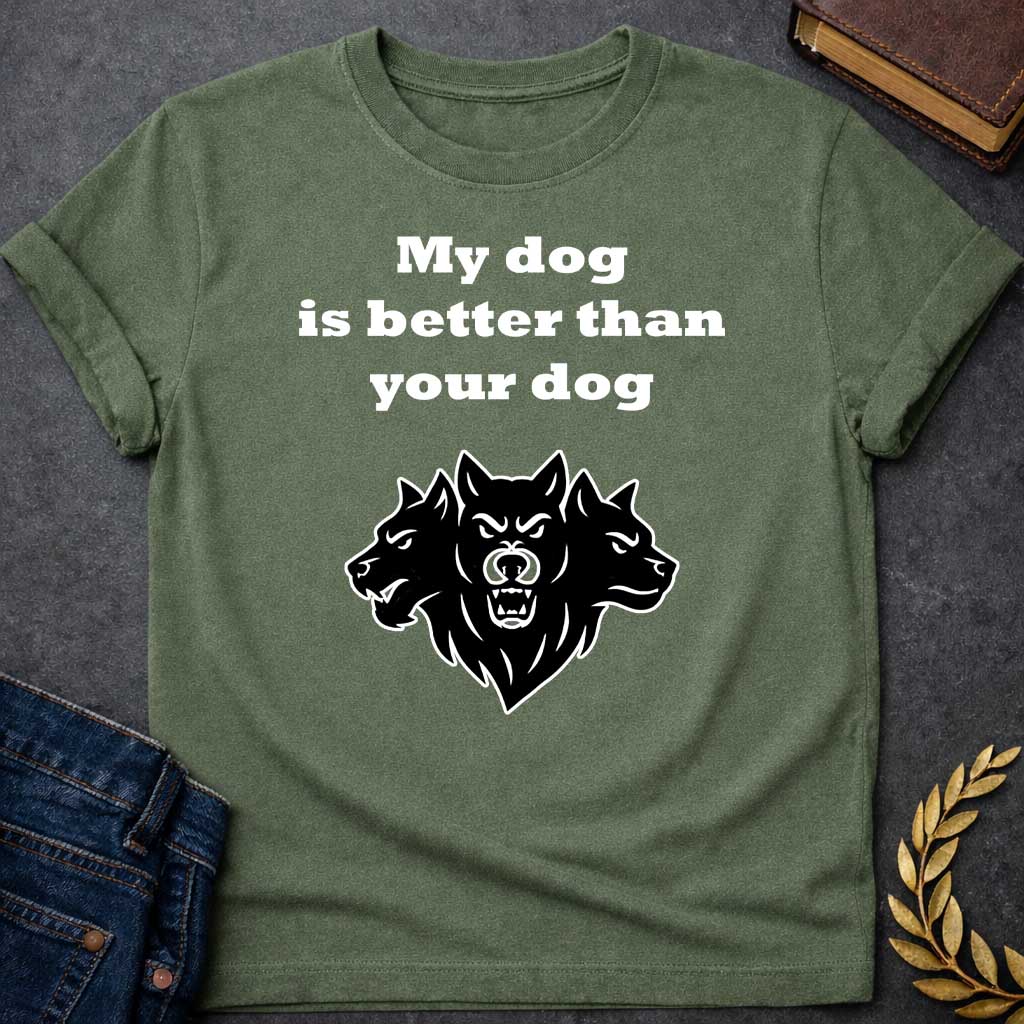 Military Green T-shirt graphic in black and white featuring bold serif text reading "My dog is better than your dog" above a flat black silhouette illustration of Cerberus, the three-headed dog of the underworld, with the center head facing forward snarling and the two side heads in profile, in a humorous nod to Hades from Greek mythology, designed for a light-coloured shirt
