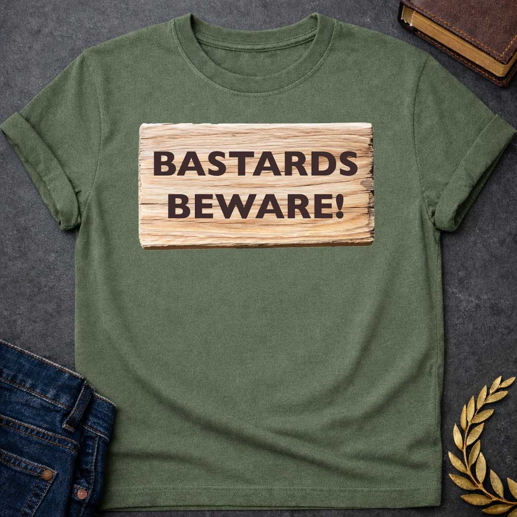 Military Green T-shirt graphic featuring a realistic illustration of a weathered and splintered wooden plank sign with bold dark brown text reading "Bastards Beware!" in a humorous nod to Hera, the Greek Queen of the Gods, known for her jealous wrath toward Zeus's illegitimate children