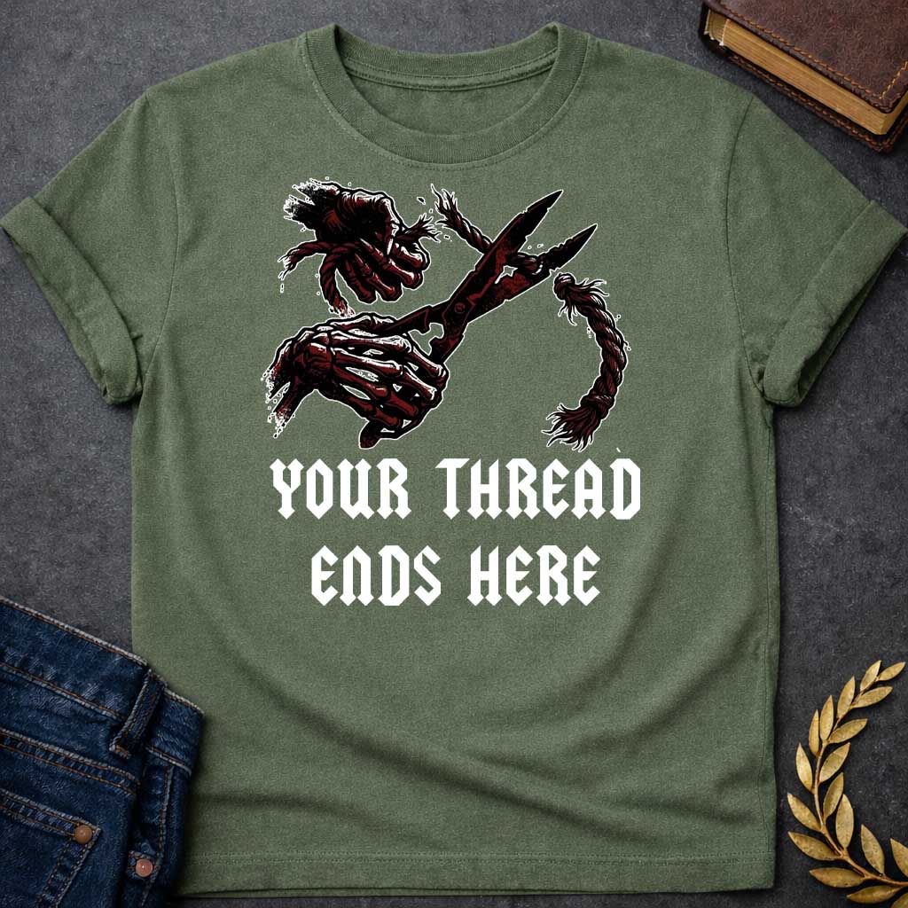 Military Green T-shirt graphic in black, white, and dark red featuring a dark illustrated scene of two skeletal hands gripping large shears cutting through a thick fraying rope or thread, rendered in a gritty horror-influenced ink style with ink splatter details. Bold heavy metal-style blackletter text below reads "Your Thread Ends Here" — a dark and dramatic reference to Atropos, the eldest of the Moirai, the Greek Fate who cuts the thread of life