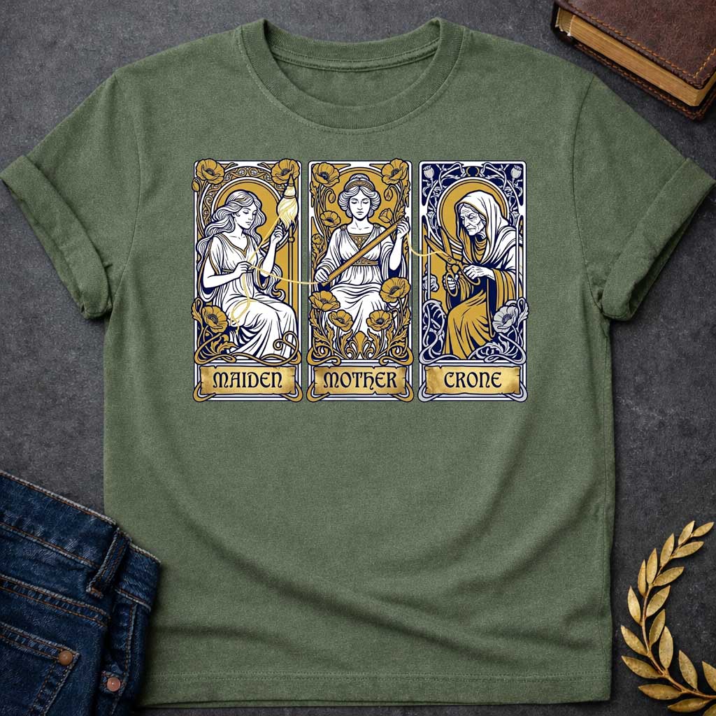 Military Green T-shirt graphic featuring three Art Nouveau-style tarot card panels in navy, gold, and white, each depicting one of the Moirai, the Greek Fates, as the triple goddess archetypes. The first panel shows the Maiden as a young woman spinning a golden thread from a spindle amid poppies, labelled "Maiden." The middle panel shows the Mother as a composed woman measuring the thread with a ruler surrounded by blooming poppies, labelled "Mother." The third panel shows the Crone as an elderly hooded wom