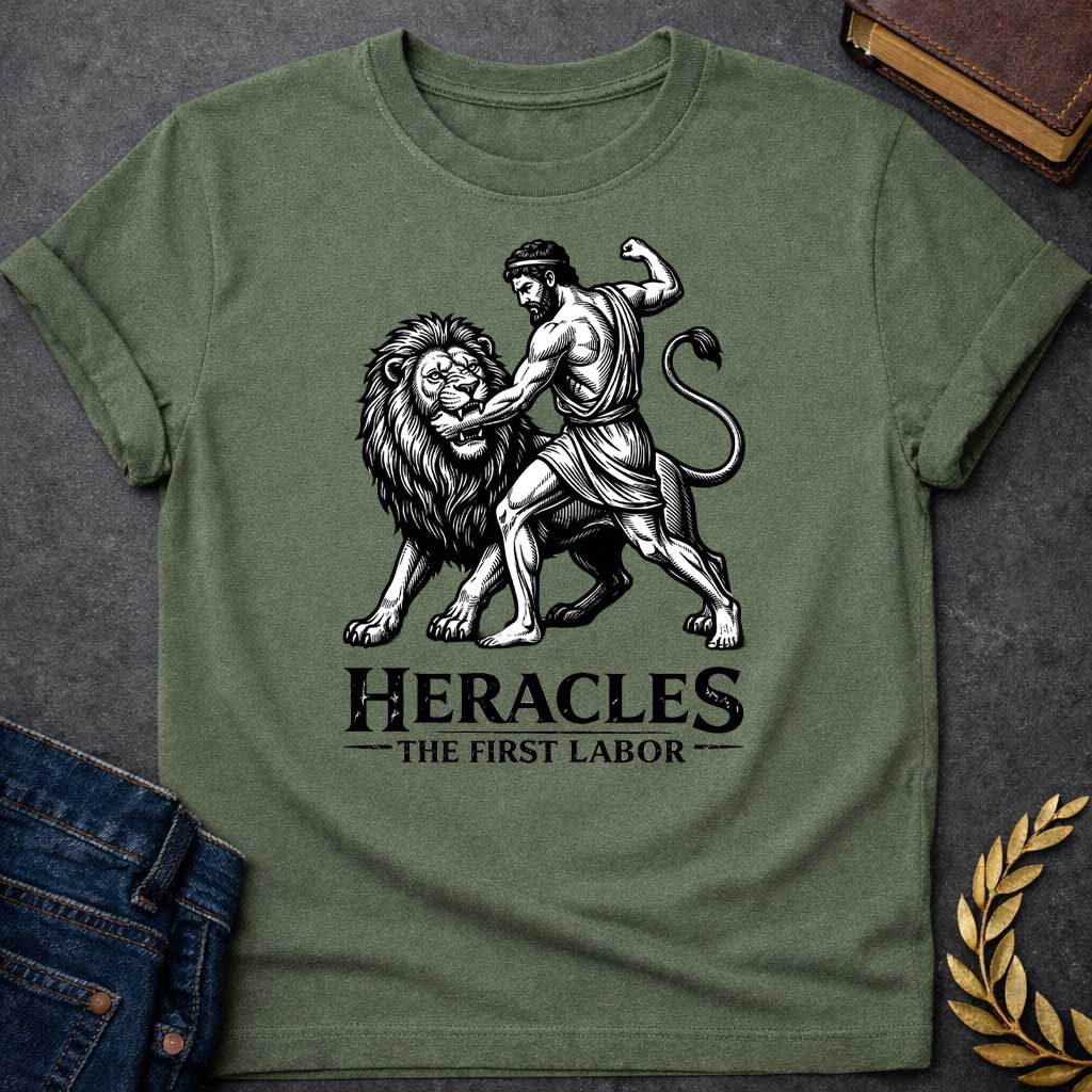 Military Green T-shirt. The illustration features a woodcut-style depiction of the Greek hero Heracles wrestling the Nemean lion. Below the artwork, the text reads in black "HERACLES" in a large, distressed serif font, followed by the smaller subtitle "THE FIRST LABOR,"