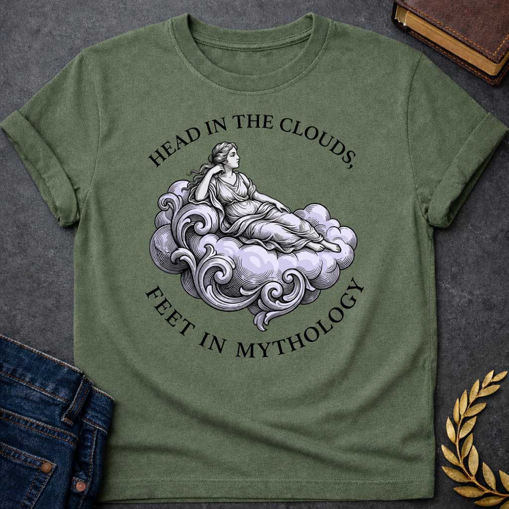 Military Green T-shirt with a classical Greek mythology t-shirt design featuring a detailed engraving-style illustration. A woman in a traditional draped chiton relaxes gracefully, reclining on a large, swirling baroque-style cloud shaded in a pale purple hue. Arched above her is the text "HEAD IN THE CLOUDS," and curved inversely below the cloud is "FEET IN MYTHOLOGY," all written in a clean black serif font.