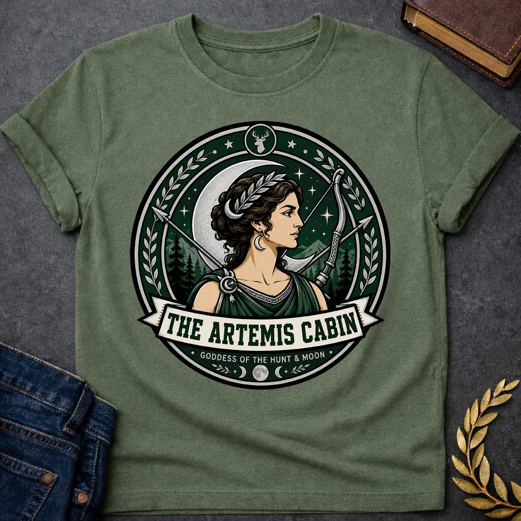 Military Green t-shirt with a Artemis Greek mythology cabin design featuring the goddess of the hunt and moon with a crescent moon, bow and arrows, forest mountains, stars, laurel branches, and deer symbol. Dark green, silver, cream, and black circular camp-style emblem includes the text “The Artemis Cabin” and “Goddess of the Hunt & Moon.”
