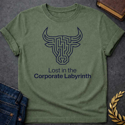 Military Green T-shirt with a Minimalist line art illustration of a Minotaur head rendered entirely as a complex maze pattern in navy blue and white. The bull's horns and facial features form pathways and corridors. Text reads 'Lost in the Corporate Labyrinth' below. Clever wordplay merges Greek mythology with modern commentary on workplace frustration, bureaucratic confusion, and corporate system entrapment.