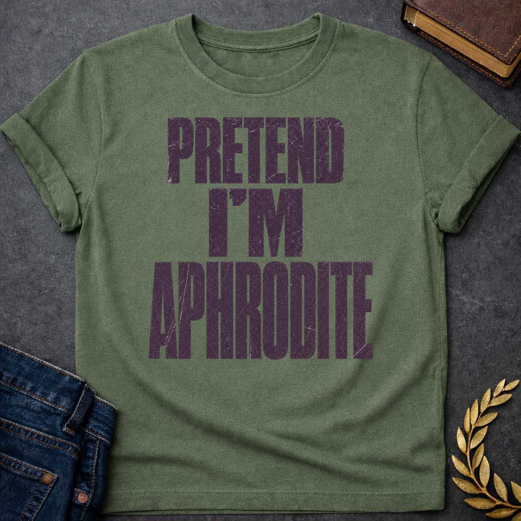 Military Green t-shirt with a Pretend I’m Aphrodite Greek mythology design featuring bold distressed purple typography on a transparent background. The stacked text reads “PRETEND I’M APHRODITE” in a rugged vintage block font, creating a simple humorous design inspired by Aphrodite, the Greek goddess of love and beauty.