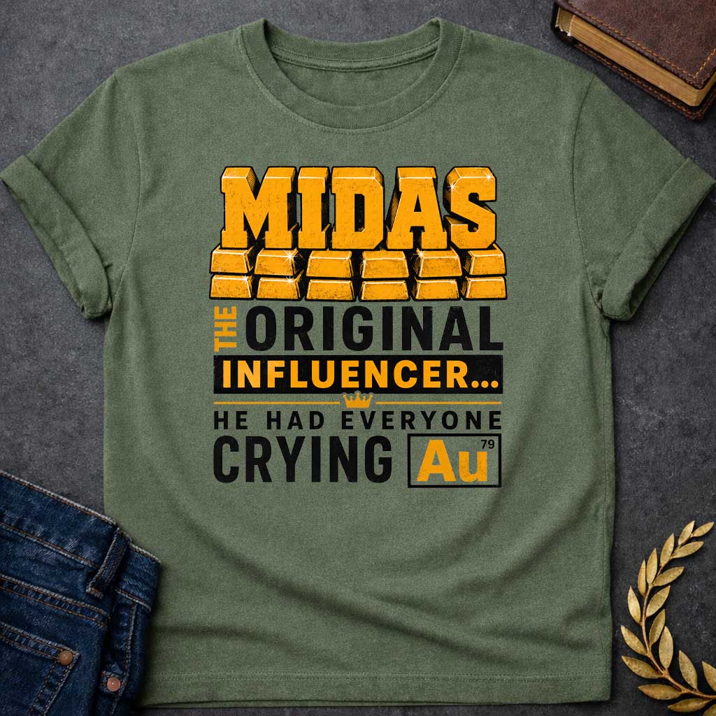 Military Green t-shirt with A Bold typographic Greek mythology design featuring stacked gold bar lettering spelling "MIDAS" above the phrase "The Original Influencer... He Had Everyone Crying Au." The design uses distressed black and metallic gold typography with a small crown icon and a gold-themed chemical element "Au" symbol, creating a humorous King Midas pun in a vintage-inspired graphic style.
