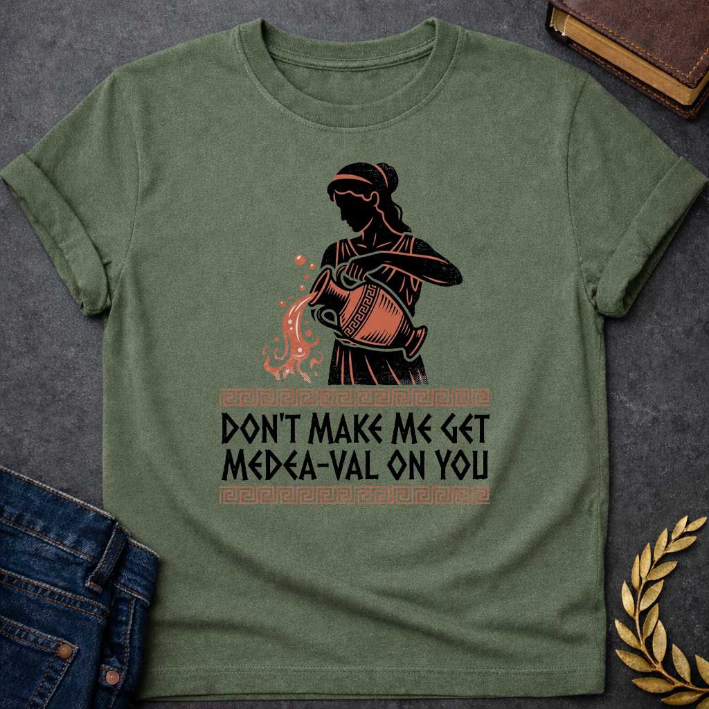 Military Green T-shirt with A Silhouetted figure of Medea, legendary Greek sorceress, rendered in black and rust-red. She wears classical robes and headband while holding an ornate cauldron with magical flames and sparks bursting forth. Greek key pattern borders frame the design. Text reads 'Don't Make Me Get Medea-Val On You' - wordplay combining her name with modern slang. Celebrates Medea's fearsome magical and destructive powers with contemporary humor.