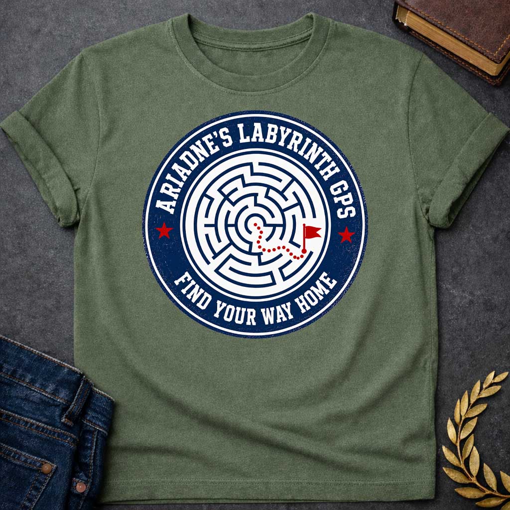Military Green T-shirt with A Circular emblem with concentric maze in navy and white, featuring a red dotted path through the labyrinth toward a flag marker. Red stars accent the design. Text reads 'Ariadne's Labyrinth GPS' around the border and 'Find Your Way Home' below. Merges Greek mythology with modern GPS technology, presenting the legendary thread as contemporary guidance. Celebrates finding home through challenging mazes.
