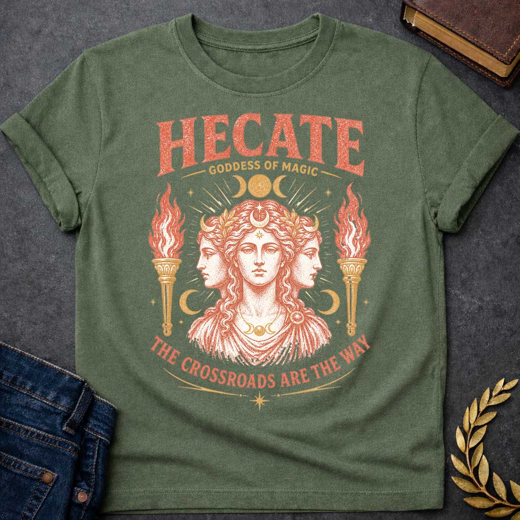 Military Green t-shirt with a Vintage Hecate Greek mythology shirt featuring the triple-formed Goddess of Magic surrounded by crescent moons, stars, radiant celestial details, and flaming torches. Distressed coral and gold artwork includes the bold text “Hecate Goddess of Magic” and “The Crossroads Are the Way,” inspired by her connection to magic and crossroads.