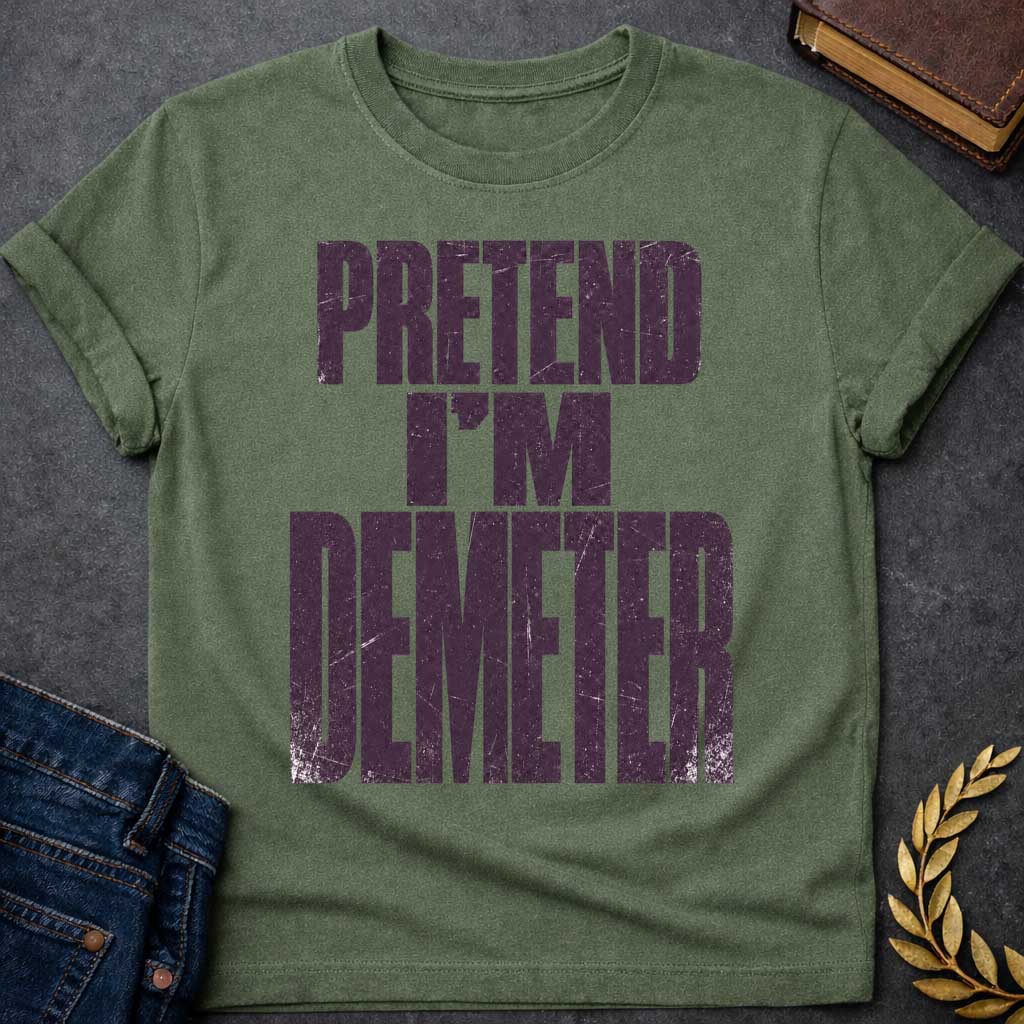 Military Green t-shirt with a Pretend I’m Demeter Greek mythology design featuring bold distressed purple typography on a transparent background. The stacked text reads “PRETEND I’M DEMETER” in a rugged vintage block font, creating a humorous design inspired by Demeter, the Greek goddess of agriculture, harvest, grain, fertility, and the earth.