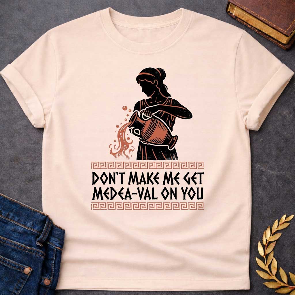 Natural T-shirt with A Silhouetted figure of Medea, legendary Greek sorceress, rendered in black and rust-red. She wears classical robes and headband while holding an ornate cauldron with magical flames and sparks bursting forth. Greek key pattern borders frame the design. Text reads 'Don't Make Me Get Medea-Val On You' - wordplay combining her name with modern slang. Celebrates Medea's fearsome magical and destructive powers with contemporary humor.