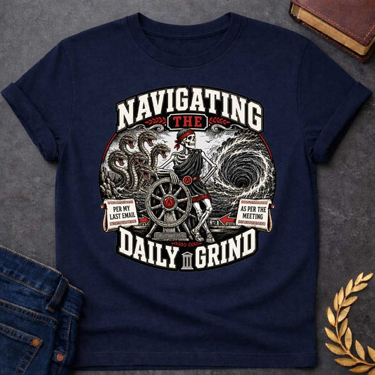 Navy t-shirt with A skeleton in a toga casually leans on a ship's wheel between a multi-headed sea monster and a churning whirlpool. Bold text reads "NAVIGATING THE DAILY GRIND," with side scrolls humorously labeled "PER MY LAST EMAIL" and "AS PER THE MEETING."