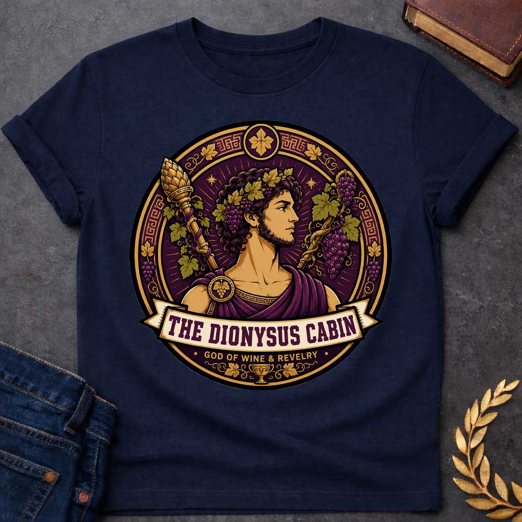 Navy t-shirt with a Dionysus Greek mythology cabin design featuring the god of wine and revelry wearing a grapevine crown and purple robes, surrounded by clusters of grapes, vine leaves, a thyrsus, Greek key patterns, and a wine cup. Purple and gold circular emblem includes the text “The Dionysus Cabin” and “God of Wine & Revelry,”