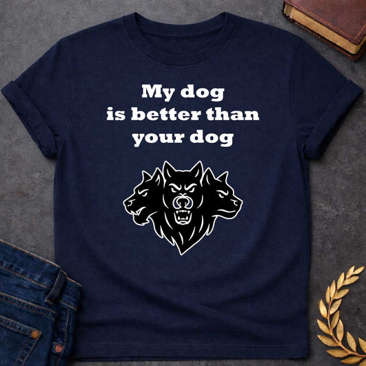 Navy T-shirt graphic in black and white featuring bold serif text reading "My dog is better than your dog" above a flat black silhouette illustration of Cerberus, the three-headed dog of the underworld, with the center head facing forward snarling and the two side heads in profile, in a humorous nod to Hades from Greek mythology, designed for a light-coloured shirt