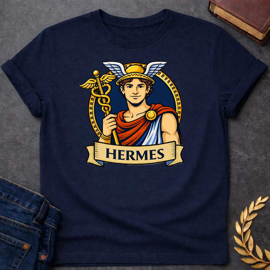 Navy T-shirt graphic featuring a vibrant illustrated portrait of Hermes, the Greek Messenger God, as a young man with curly brown hair wearing a gold winged helmet, dressed in a red and blue draped robe fastened with a gold brooch, holding a golden caduceus staff entwined with two serpents and topped with wings. He is framed within a gold circular border against a navy background, with a scroll banner below reading "Hermes," in a bold tattoo-inspired style with navy, gold, and red tones