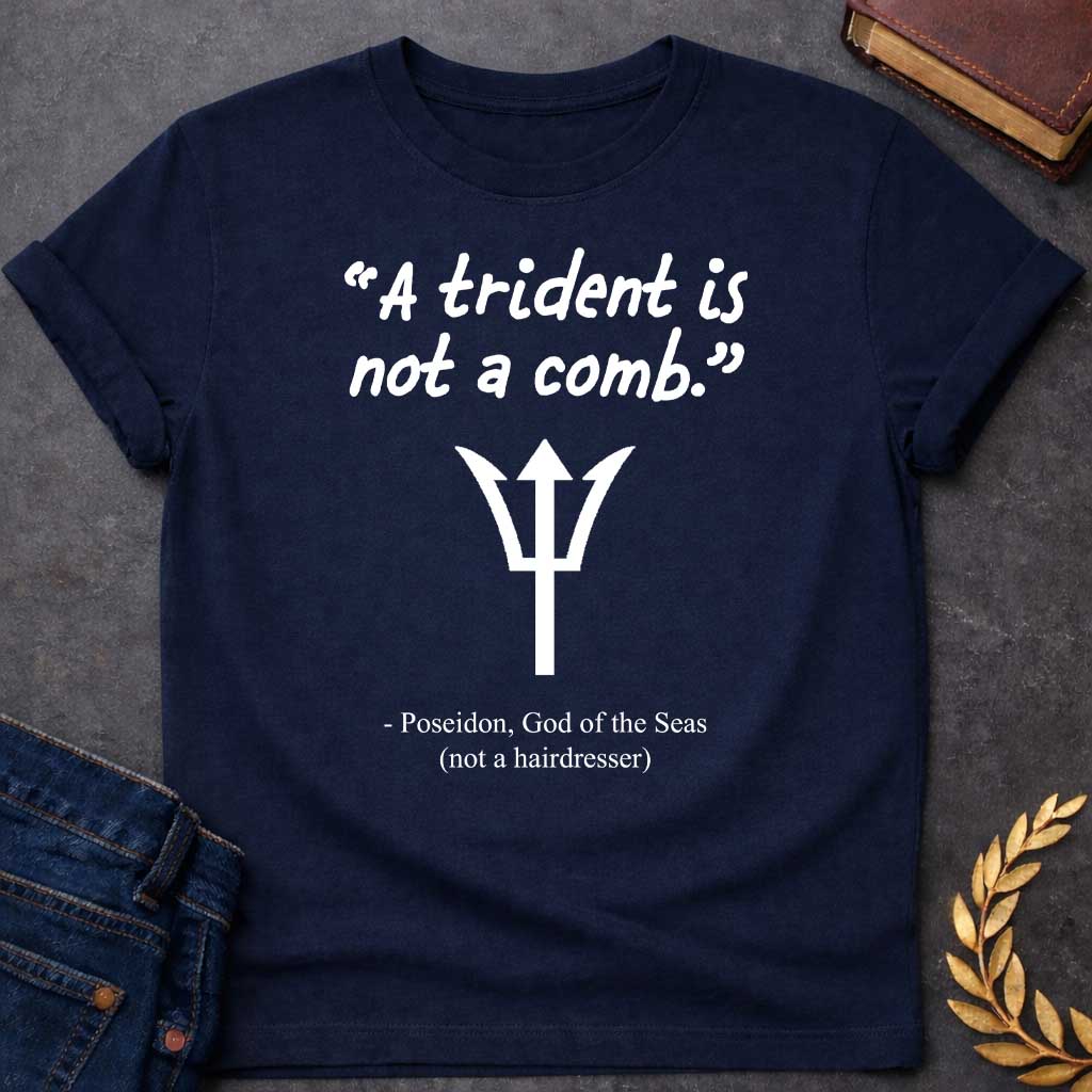 Navy T-shirt graphic featuring a white handwritten-style quote reading "A trident is not a comb." above a flat white trident symbol, with the humorous attribution below in clean serif text reading "- Poseidon, God of the Seas (not a hairdresser)