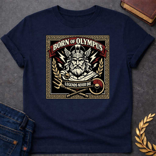Navy T-shirt graphic featuring a bold vintage label-style design with a Greek meander border in gold. A red arched banner at the top reads "Born of Olympus" above a front-facing illustration of Zeus with long white hair and beard wearing a winged helmet, surrounded by radiating lightning bolts and flanked by golden laurel branches. A crossed trident and scepter with a red shield sit below, with a scroll banner reading "Legends Never Die," rendered in black, gold, cream, and red tones