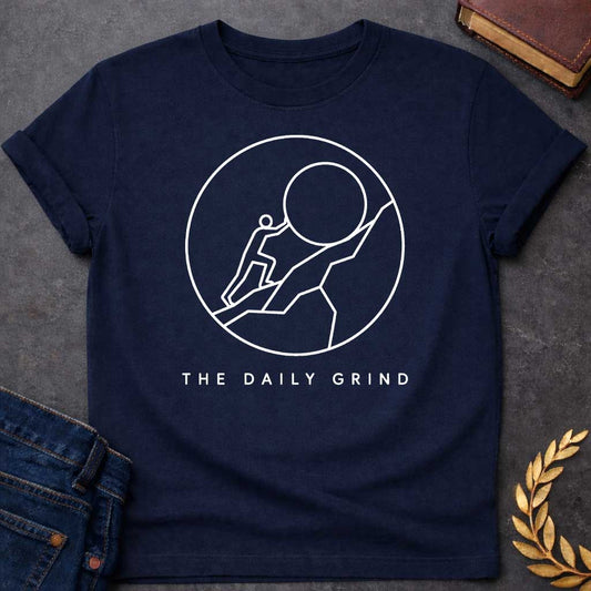 Navy T-Shirt with a minimalist white graphic design.  Inside a thin circle is a simple line-art illustration of a stick figure pushing a large boulder up a steep hill, representing the myth of Sisyphus. Below the circle, the text reads "THE DAILY GRIND" in a clean, sans-serif font.