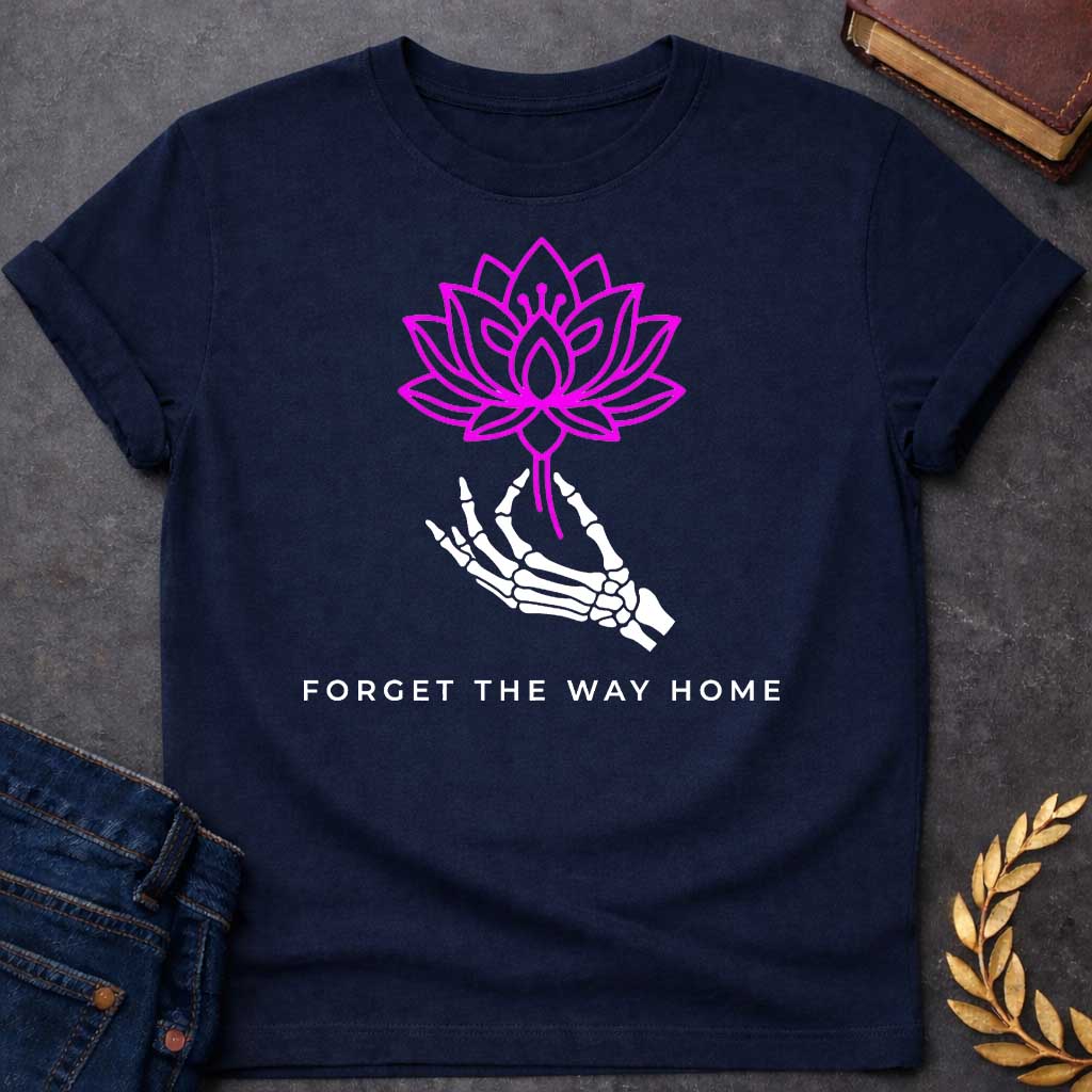 Navy T-shirt with a graphic featuring a bold magenta line-art lotus flower held delicately by a white skeletal hand, with spaced bold sans-serif text below reading "Forget the Way Home" — a darkly humorous reference to the Land of the Lotus-Eaters episode in Homer's Odyssey, where Odysseus's crew ate lotus flowers and forgot their desire to return home