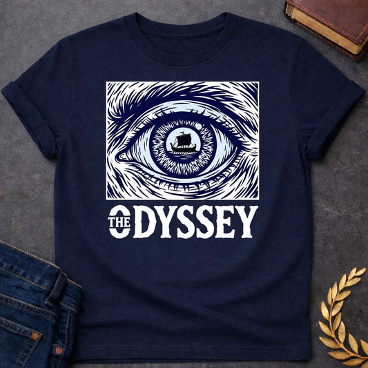 Navy T-Shirt with a dramatic graphic design for 'The Odyssey' featuring a stylized eye in navy blue and white. The iris contains a silhouette of an ancient Greek ship with a single sail, surrounded by radiating lines suggesting both an iris pattern and oceanic waves. Swirling, turbulent linework evokes stormy seas and Odysseus's tumultuous journey. Bold serif text reads 'THE ODYSSEY' in white. Combines classical maritime imagery with modern design, emphasizing vision, journey, destiny, and fate.